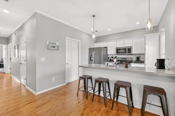 a kitchen with stainless steel appliances a dining table chairs microwave and sink