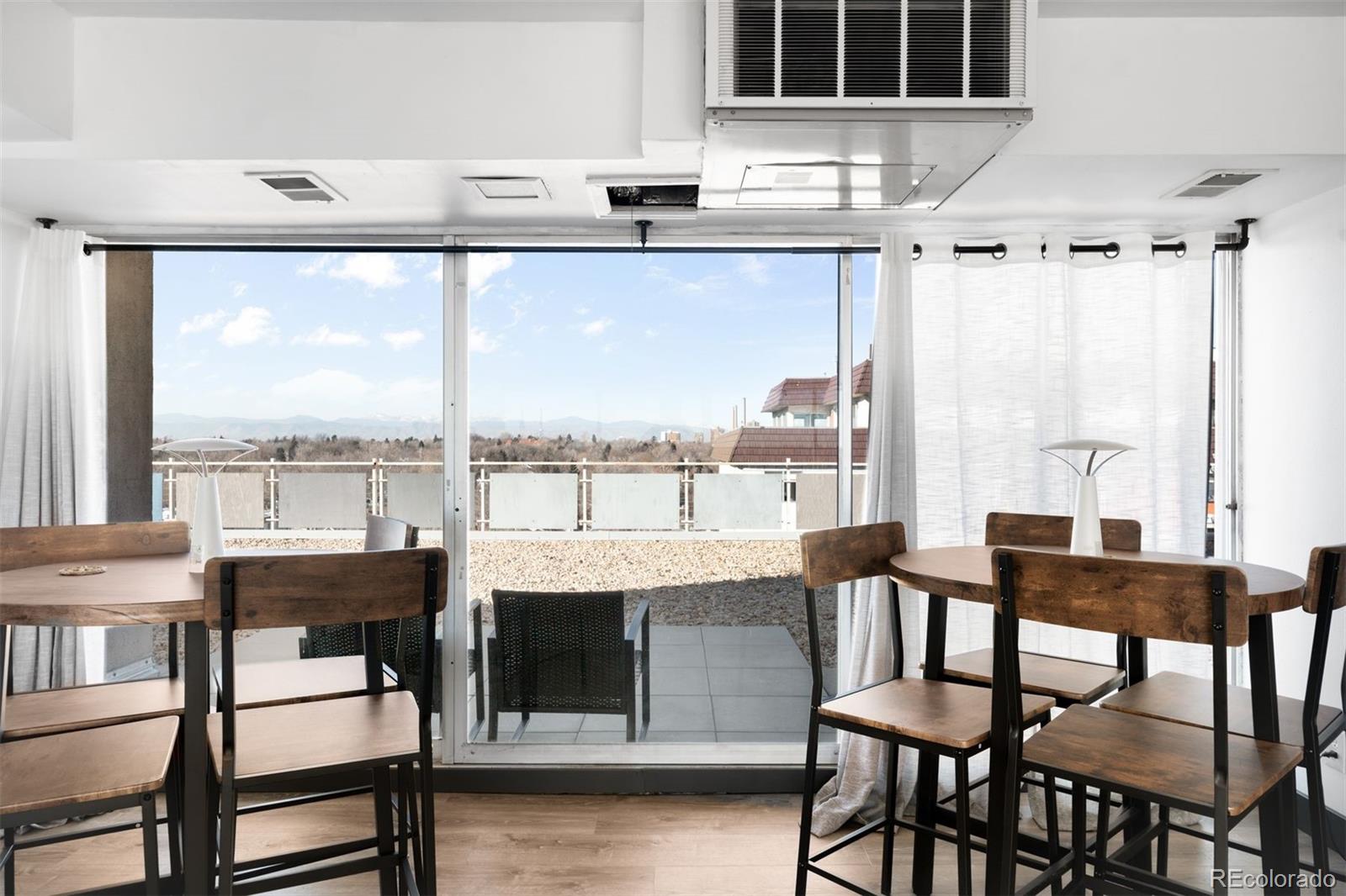 1121 Albion Street, Unit 704 Denver, CO 80220 - Photo 15 of 25 a dining room with furniture window wooden floor and a table