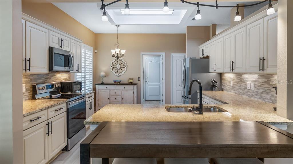 4232 Newland Street Clermont, FL 34711 - Photo 14 of 45 a kitchen with kitchen island a sink appliances and cabinets