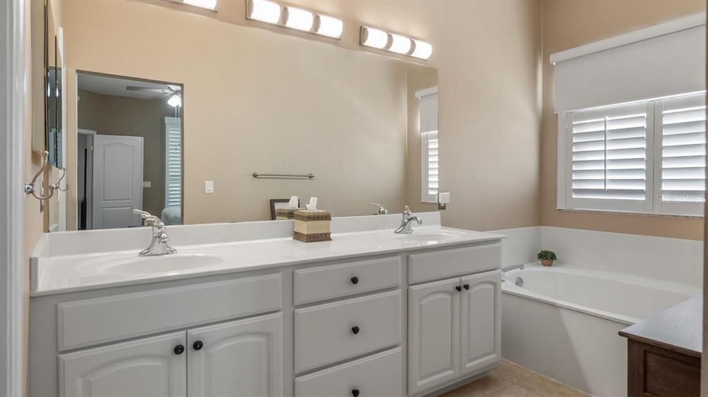 4232 Newland Street Clermont, FL 34711 - Photo 23 of 45 a bathroom with a sink double vanity granite tub shower and a mirror