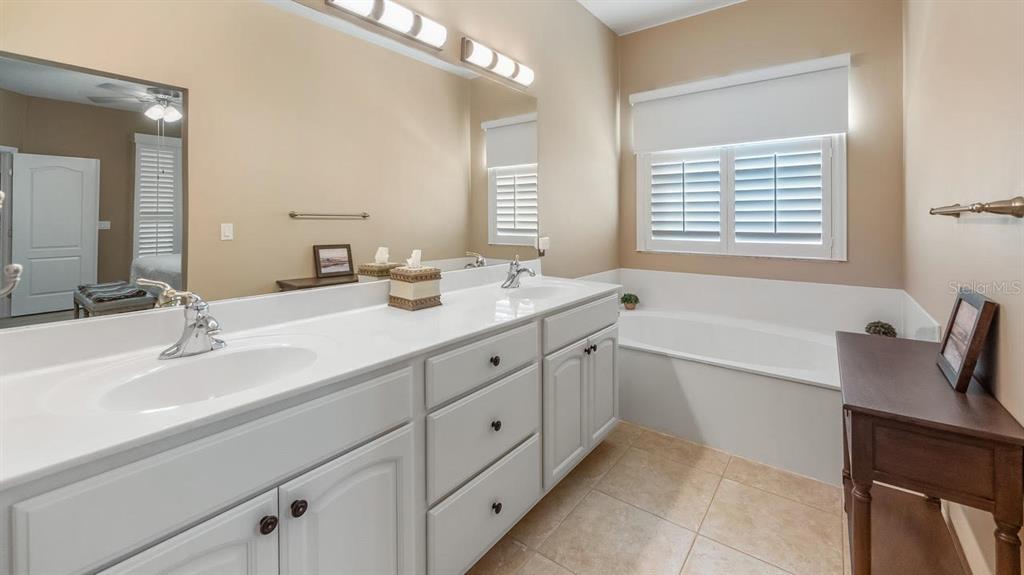 4232 Newland Street Clermont, FL 34711 - Photo 24 of 45 a bathroom with double vanity sink a mirror and a bathtub