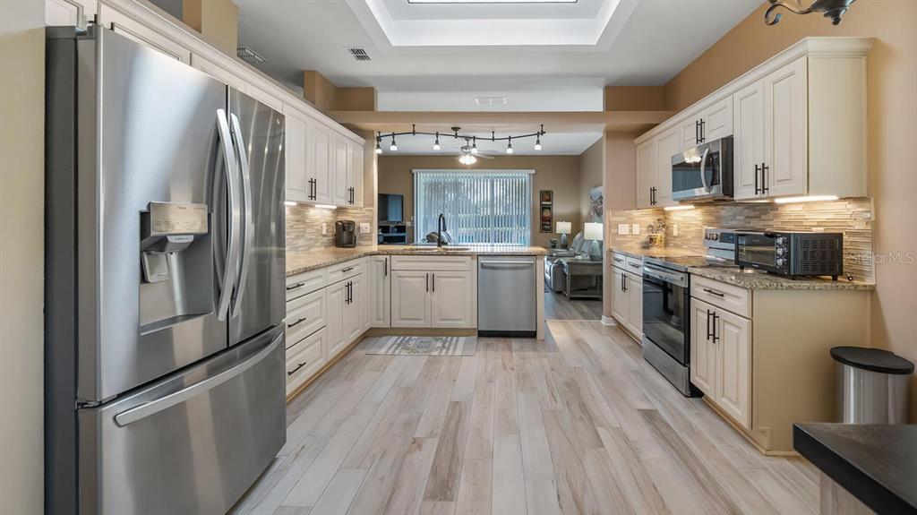 4232 Newland Street Clermont, FL 34711 - Photo 4 of 45 a kitchen with stainless steel appliances a refrigerator sink and cabinets