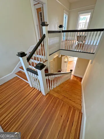 a view of a hallway view with wooden floor and staircase
