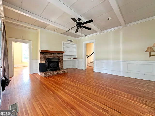 a view of empty room with wooden floor fireplace and windows