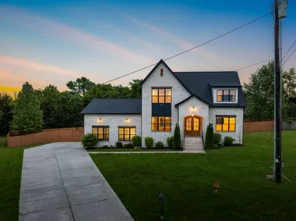 a front view of a house with yard and green space