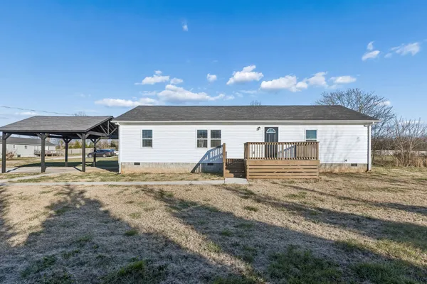 a view of a house with backyard and a tree