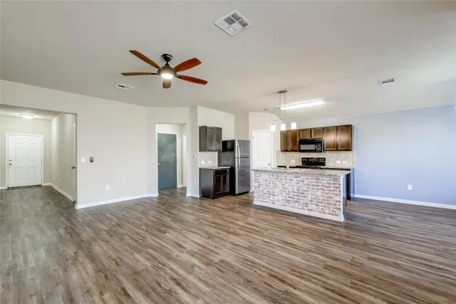 a view of kitchen with microwave refrigerator and stove