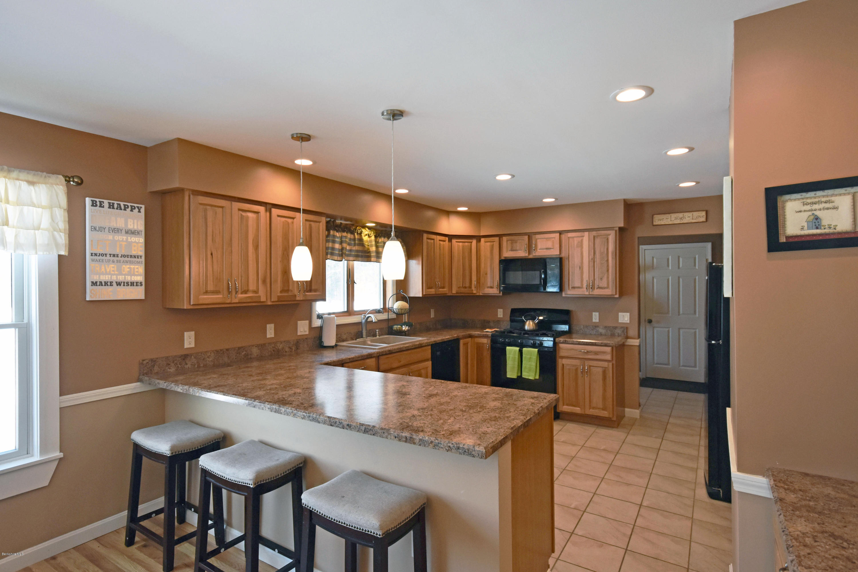 a kitchen with stainless steel appliances granite countertop a sink and a refrigerator