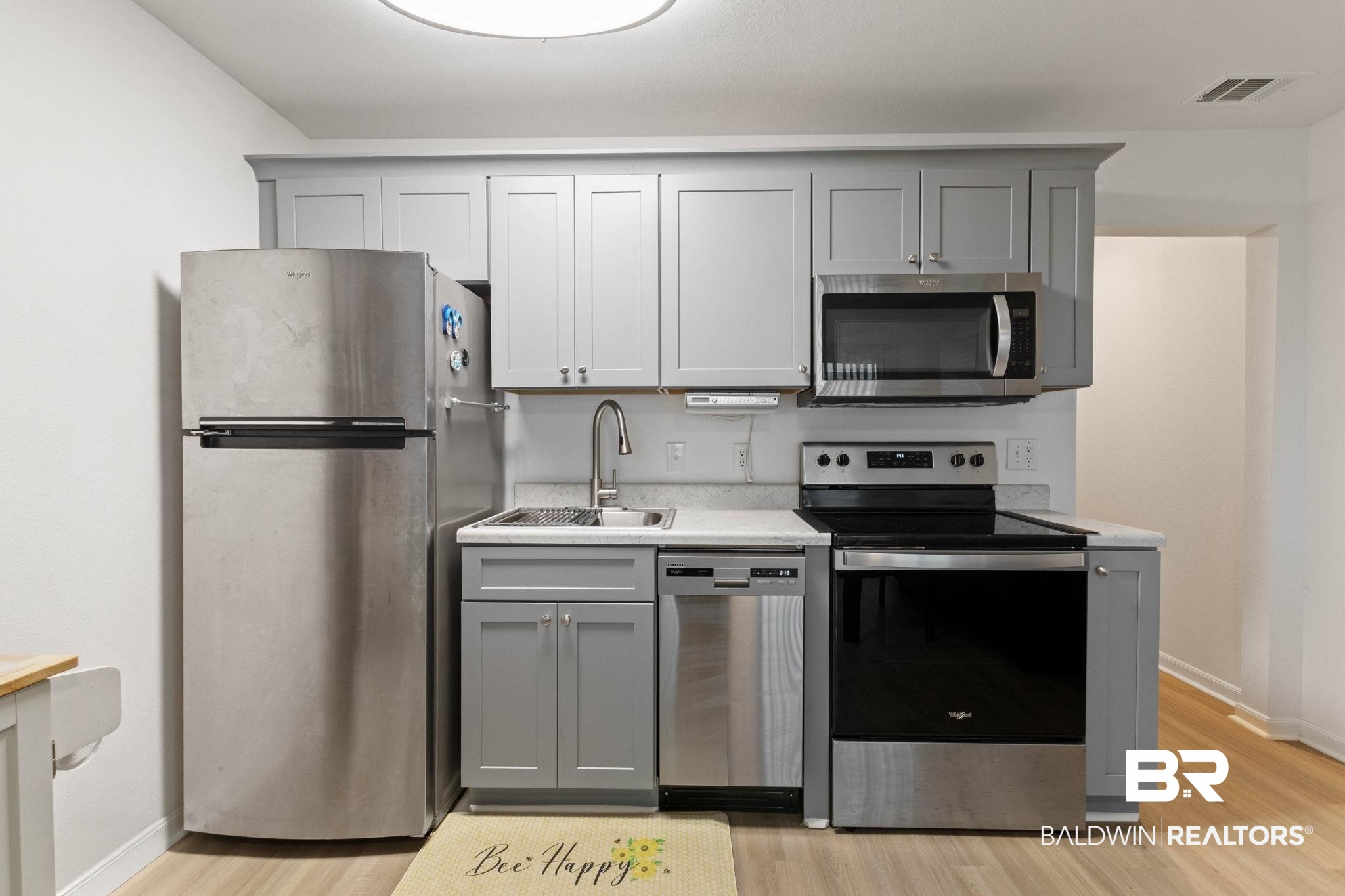 400 Plantation Road, Unit 4501 Gulf Shores, AL 36542 - Photo 7 of 30 Kitchen featuring stainless steel appliances, shaker-style cabinetry, light-colored countertops, and wood-finish flooring