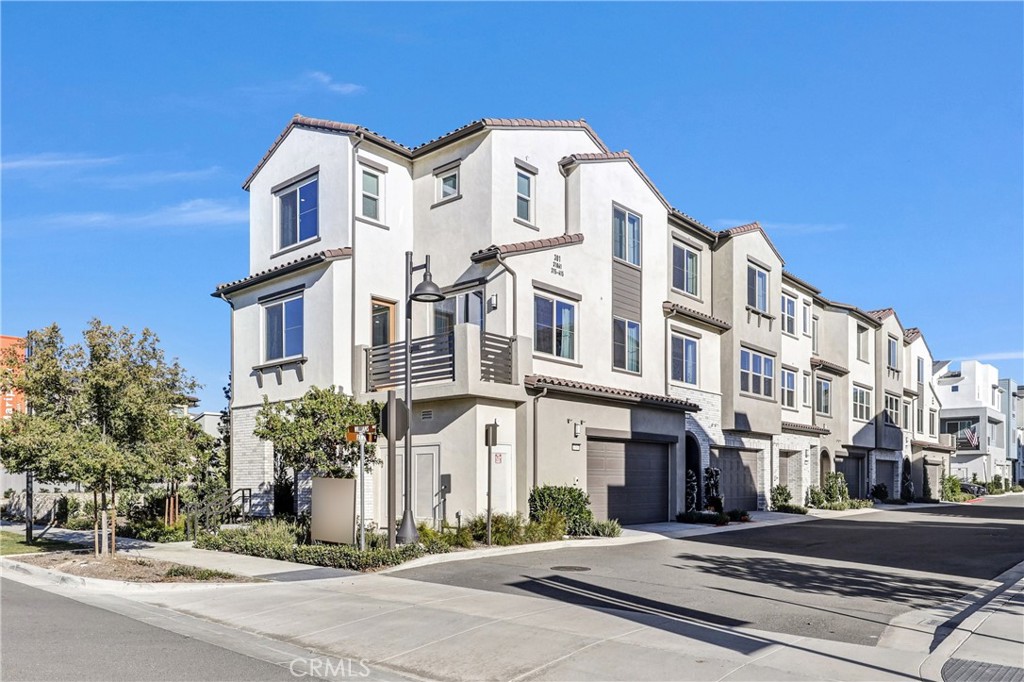 a view of a white building among the street with palm trees