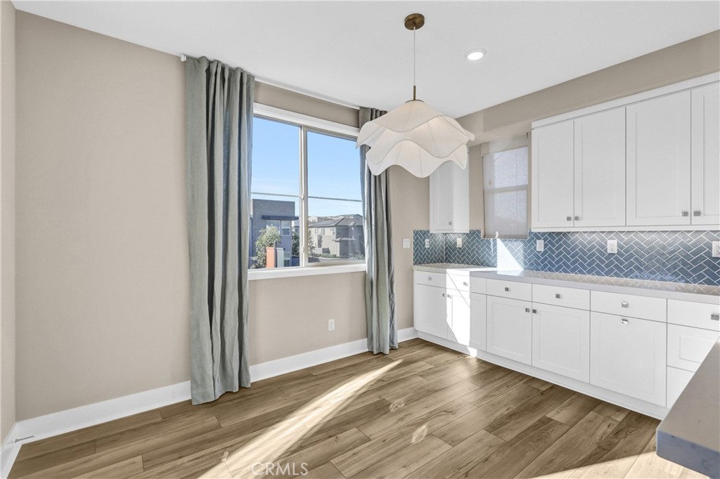 31861 Williams Way Rancho Mission Viejo, CA 92694 - Photo 7 of 28 a large kitchen with granite countertop a refrigerator a sink dishwasher a stove and white cabinets with wooden floor
