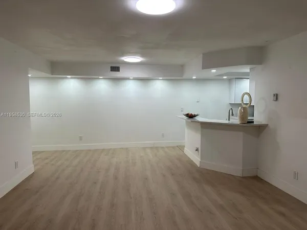 a view of a kitchen with a sink and wooden floor