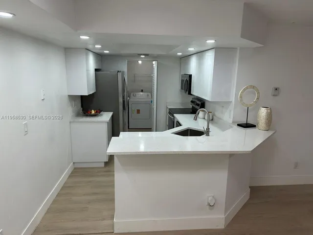 a kitchen with a refrigerator sink and cabinets