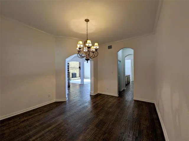 a view of a room with wooden floor chandelier and a window