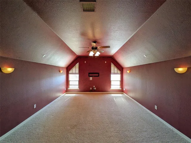 an empty room with a window and a ceiling fan