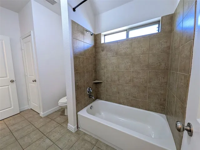 a bathroom with a bathtub a toilet and a shower