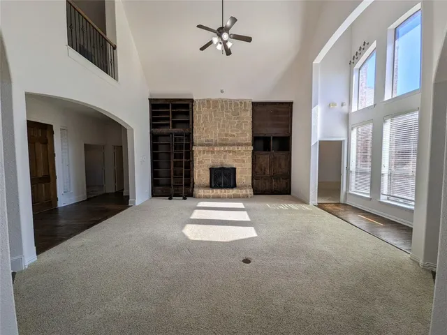 an empty room with fireplace and windows