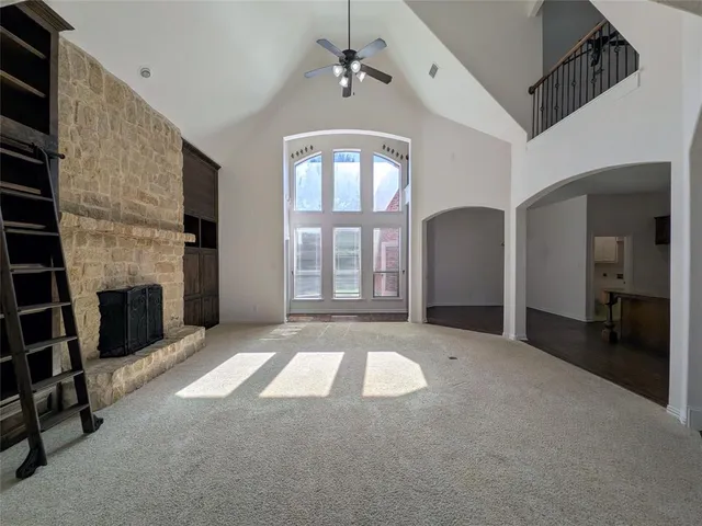 a view of an empty room with a fireplace and a window