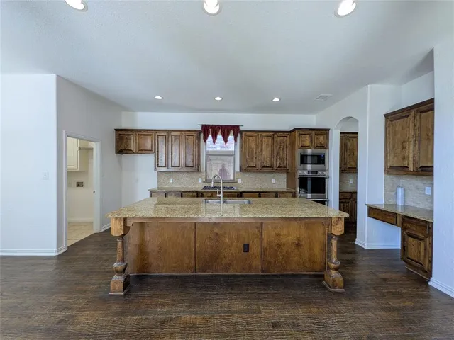 a large kitchen with stainless steel appliances granite countertop a large counter top and a stove