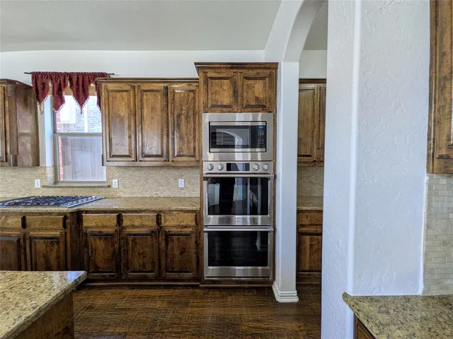 a kitchen with stainless steel appliances granite countertop a stove and a microwave