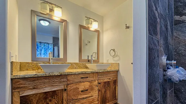 a bathroom with a granite countertop sink and a mirror
