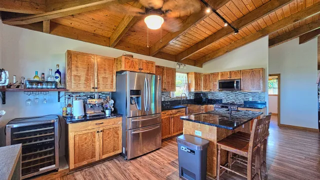 a open kitchen with stainless steel appliances granite countertop a stove a sink dishwasher and cabinets with wooden floor