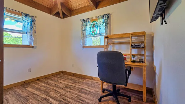a view of a workspace with furniture and a window