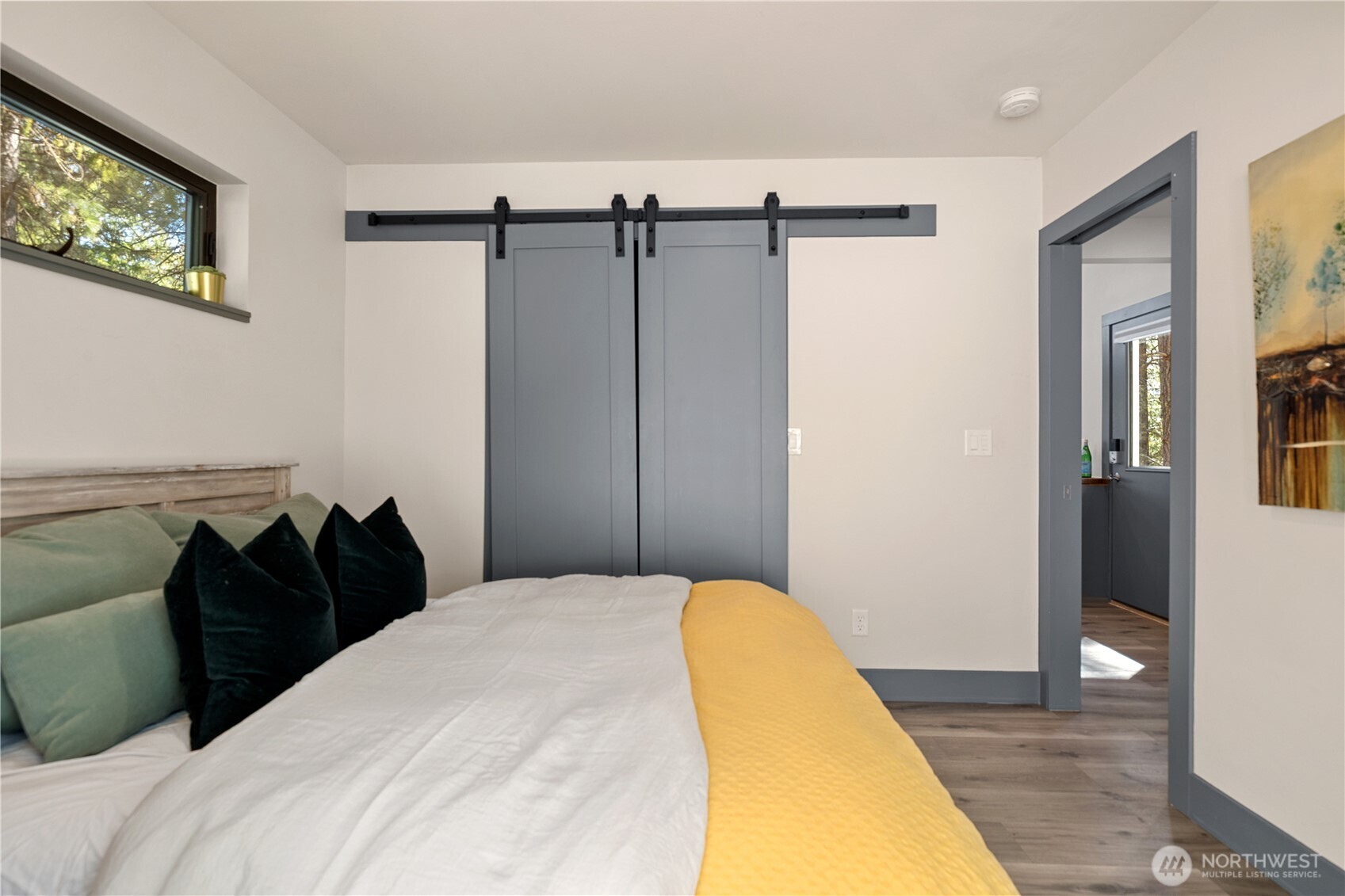 8056 Bayne Road Leavenworth, WA 98826 - Photo 36 of 40 a bedroom with a bed and a painting on the wall