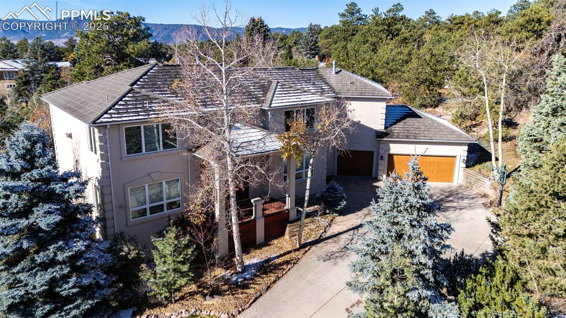 19340 Furrow Road Monument, CO 80132 - Photo 1 of 50 View of front facade with a garage, driveway, stucco siding, and a mountain view