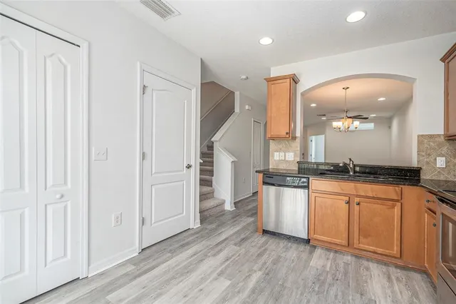 a large kitchen with a wooden floor and stainless steel appliances