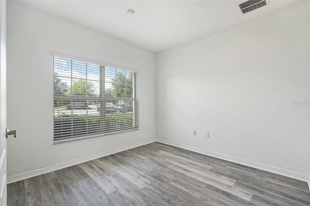 15854 Stable Run Drive Spring Hill, FL 34610 - Photo 20 of 28 an empty room with wooden floor and windows