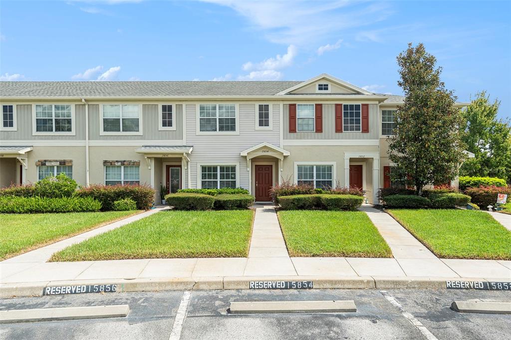 15854 Stable Run Drive Spring Hill, FL 34610 - Photo 2 of 28 a view of a white house with a yard and potted plants