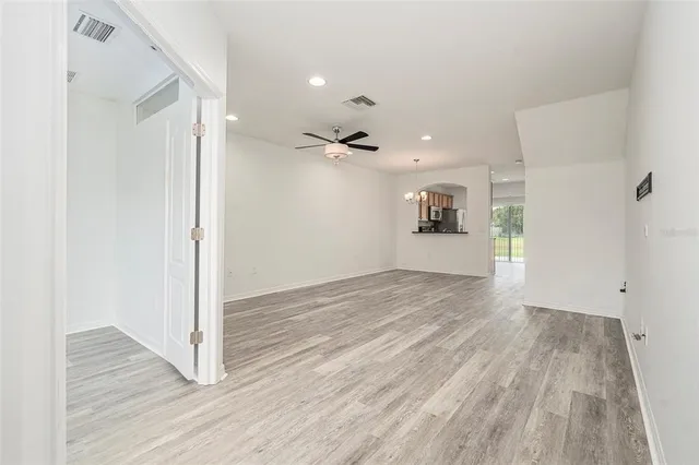 a view of a big room with wooden floor and windows