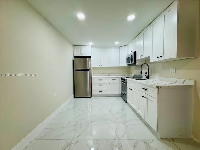 a kitchen with stainless steel appliances granite countertop a refrigerator sink and cabinets