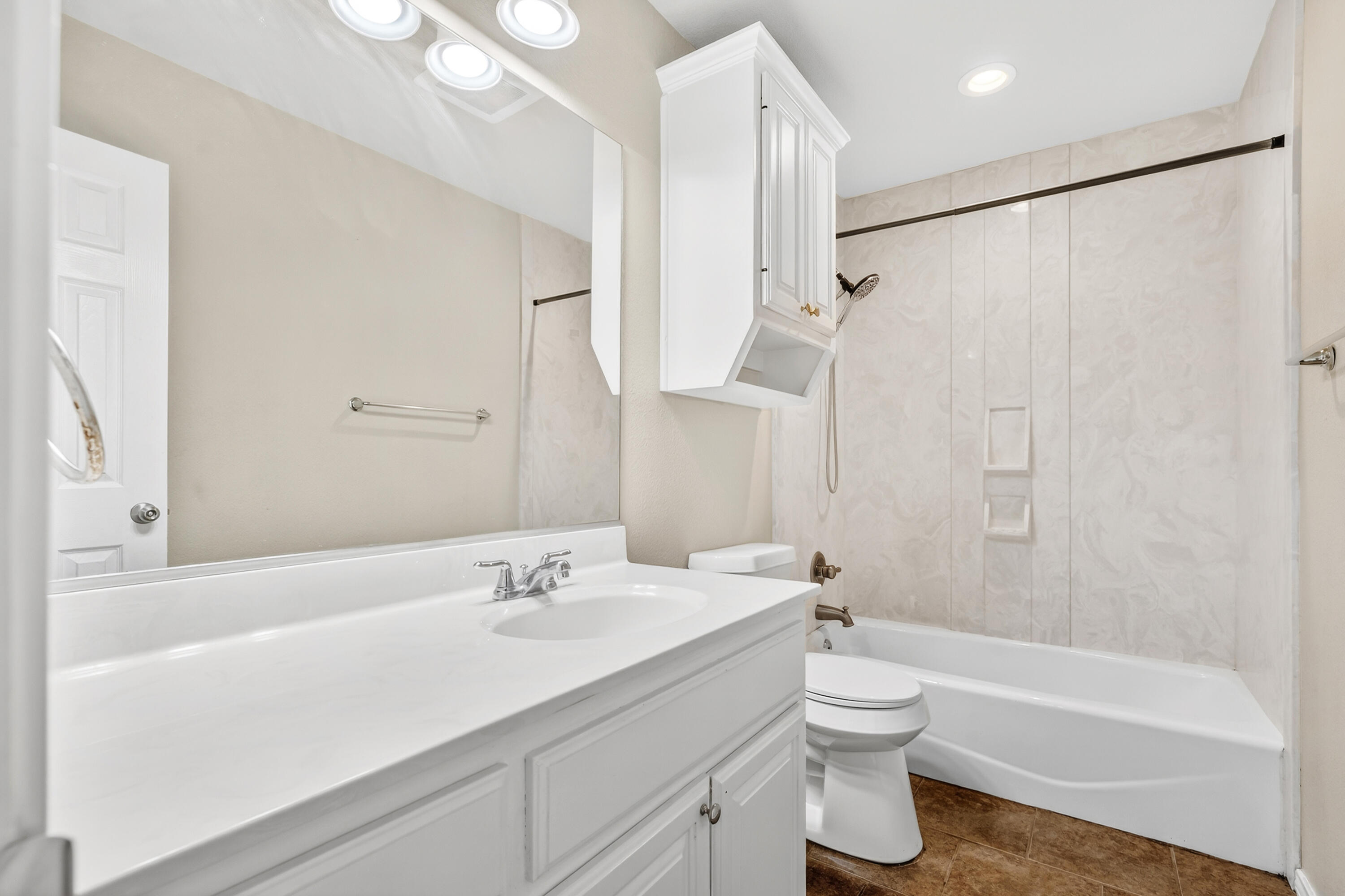 2415 93rd Street Lubbock, TX 79423 - Photo 19 of 24 a bathroom with a sink a toilet and a bathtub