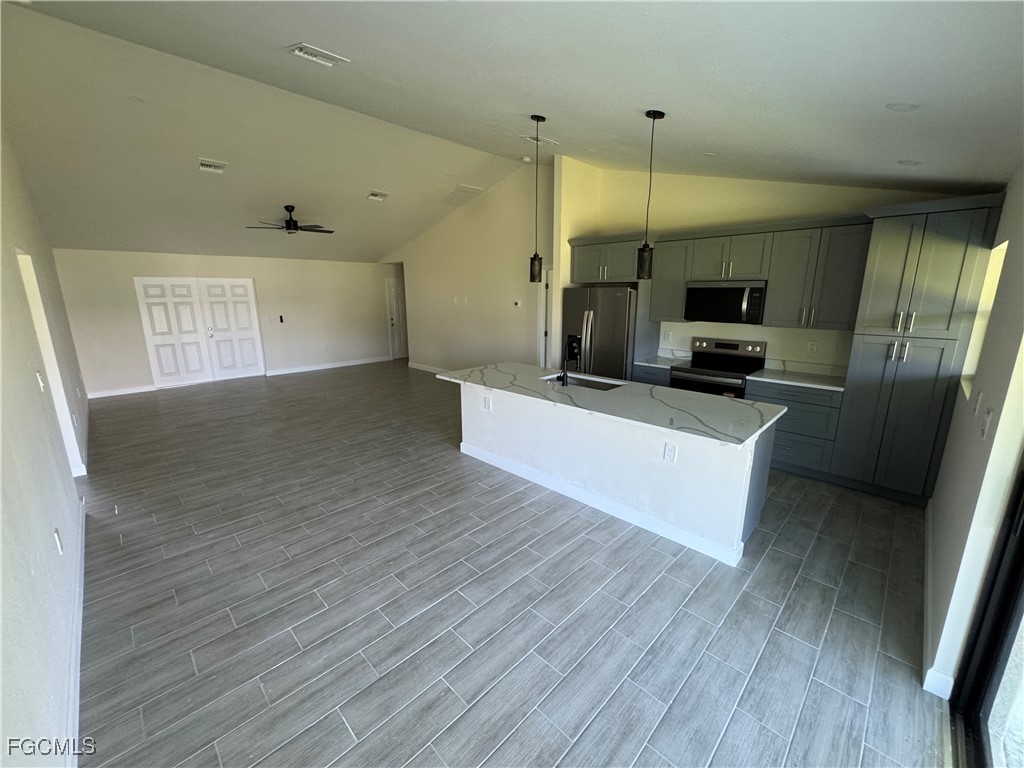 6108 Holt Court Fort Myers, FL 33905 - Photo 4 of 19 a large kitchen with a wooden floor and stainless steel appliances