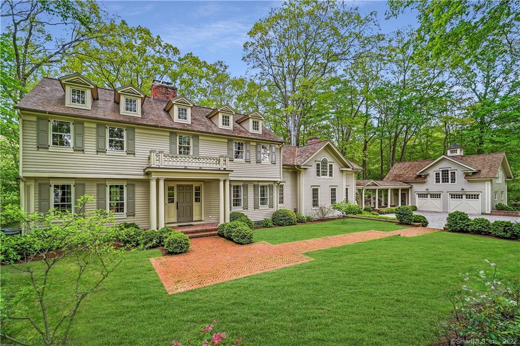 a front view of a house with a yard and trees