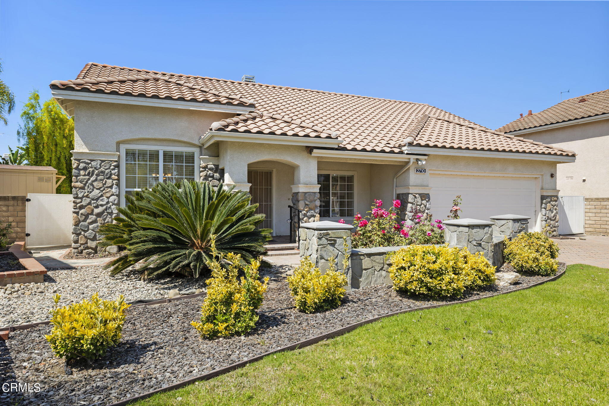 2710 Windcrest Place Oxnard, CA 93036 - Photo 3 of 34 a front view of a house with lots of potted plants