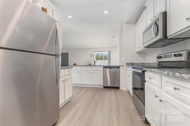 a kitchen with white cabinets and white appliances