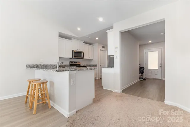 a view of kitchen with microwave and cabinets