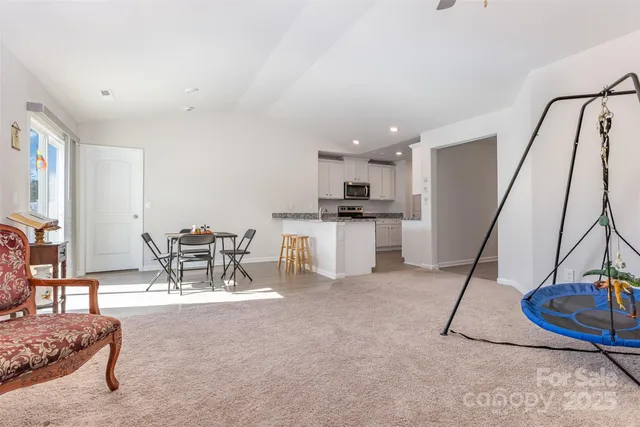 a living room with furniture a wooden floor and white walls