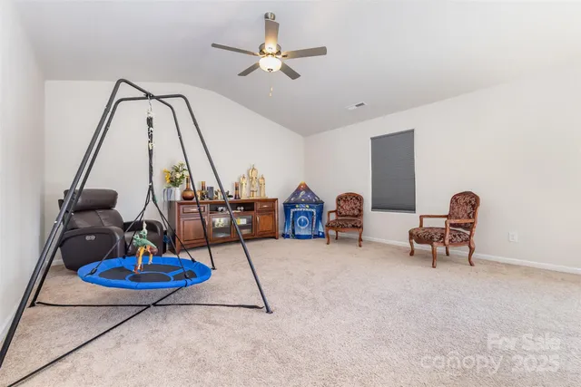 a living room with furniture a flat screen tv and a chandelier