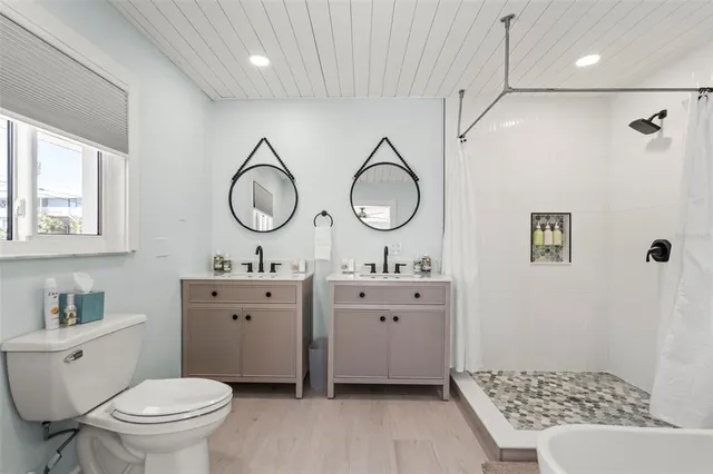 a bedroom with a bed window and mirror