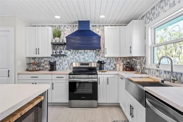 a kitchen with a stove sink and cabinets
