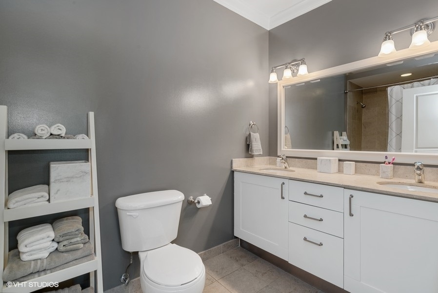 744 North Clark Street, Unit 501 Chicago, IL 60654 - Photo 11 of 16 a bathroom with a toilet a sink and mirror