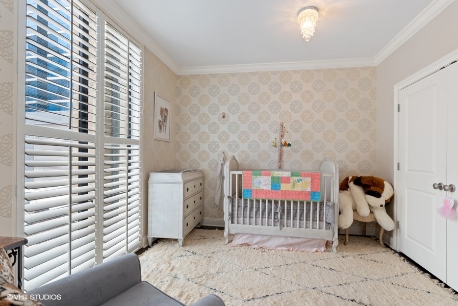 744 North Clark Street, Unit 501 Chicago, IL 60654 - Photo 13 of 16 a bedroom with a baby crib and a couch