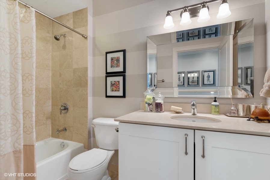 744 North Clark Street, Unit 501 Chicago, IL 60654 - Photo 15 of 16 a bathroom with a granite countertop sink mirror toilet and bathtub