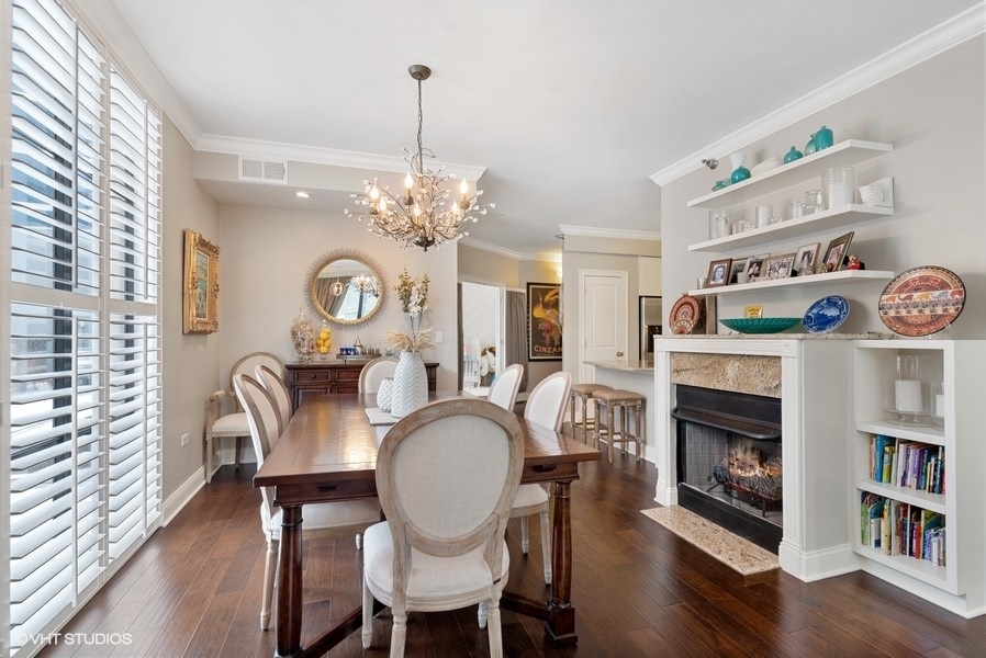 744 North Clark Street, Unit 501 Chicago, IL 60654 - Photo 6 of 16 a view of a dining room with furniture a chandelier and wooden floor