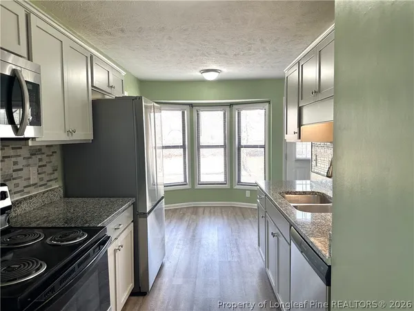 a kitchen with stainless steel appliances granite countertop a stove and a refrigerator
