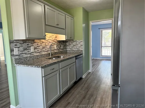 a kitchen with granite countertop a sink and cabinets